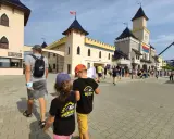 Familia paseando por un parque temático en Polonia con niños.