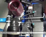 Nahaufnahme eines Nitromethan-Autos, bei dem eine Hand mit einem Schraubendreher an der Mechanik arbeitet.