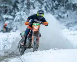 Motocyklista w akcji podczas wyścigu enduro w zimowej scenerii. To właśnie jest **enduro co to** za sport!
