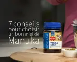 Un pot de miel de Manuka MGO 100+ à côté d'un smoothie aux fruits. Découvrez les miel de manuka bienfaits pour votre santé.