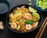 Makaron chow mein z krewetkami, warzywami i limonką, podany z sosem sojowym i imbirem.