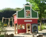 Parque infantil en Holanda con casita de panadería, columpios y tobogán. Ideal para que los niños jueguen y se diviertan.