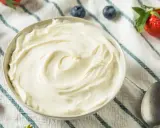 Un bol de chantilly mascarpone onctueuse, garni de fraises et de myrtilles. Parfait pour un dessert léger.