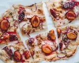Flammkuchen mit Pflaumen, Zwiebeln und Walnüssen. Ein köstlicher Flammkuchen Belag, der süß und herzhaft kombiniert.