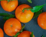 Kilka soczystych mandarynek z zielonymi listkami. Zastanawiasz się, ile kcal mają mandarynki? Są niskokaloryczne i zdrowe!