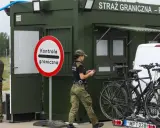 Strażnicy graniczni prowadzą kontrole na granicy niemieckiej. Obok zielonego punktu kontrolnego stoją dwa rowery na bagażniku samochodu.