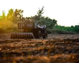 ATV with a roller attachment, ready for field work. This is one of many tractor attachments that can help prepare the soil.