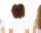Drei Frauen von hinten: glattes, gefärbtes Haar; lockiges Haar mit hoher Porosität; welliges, blondes Haar.