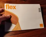 Dłoń trzyma kopertę z napisem "flex" i logo Orange. To oferta Orange Flex.