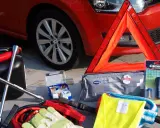 Gadżety przydatne w podróży: kanister, klucz, apteczka, trójkąt ostrzegawczy, latarka, kamizelka odblaskowa i kable rozruchowe.