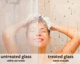 Mampara de ducha con vidrio tratado vs. sin tratar. El lado tratado muestra gotas de agua deslizándose, facilitando su limpieza.