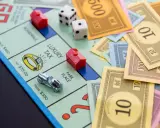 Na planszy Monopoly leżą pionki, kostki i banknoty. Czas na wielką rozgrywkę, ale gramy!