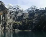 Majestatyczne Tatry Wschodnie z ośnieżonymi szczytami odbijają się w spokojnej tafli jeziora.