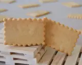 Deux biscuits rectangulaires aux bords festonnés, parfaits pour une recette biscuit personnalisé. Ils reposent sur des petites palettes en bois.