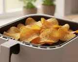 Knusprige Kartoffelchips, frisch aus dem Airfryer, warten darauf, genossen zu werden.
