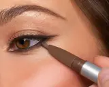 Ojo marrón con delineado invertido, aplicando lápiz marrón en la línea de agua inferior para un look dramático.