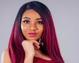Una giovane donna con capelli color prugna, un look audace che le sta benissimo.