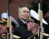 Władimir Putin w otoczeniu żołnierzy w mundurach, gdzieś w tle widać ceglany mur. To obraz, który przypomina o dawne słowo honoru.