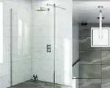 Box doccia moderno con pannelli in vetro e rivestimento in marmo. La doccia a soffitto e il soffione a parete sono in finitura cromata. L'altezza del rivestimento doccia è ben visibile.