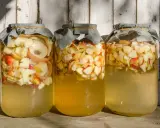 Trois bocaux remplis de pommes coupées, prêts pour la vinaigre de cidre recette de grand-mère.