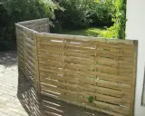 Ett enkelt vindskydd av trä, perfekt för att bygga en mysig vrå i trädgården.