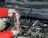 Mechanik używa preparatu do czyszczenia wtryskiwaczy w silniku diesla.