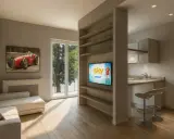 Soggiorno moderno con divano, quadro d'auto d'epoca e cucina a vista. Perfetto per chi cerca case ristrutturate con stile.
