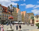 Tętniący życiem Rynek we Wrocławiu, kolorowe kamienice i ludzie spacerujący po placu. To wspaniałe wrocławskie atrakcje!