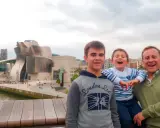 Familia disfrutando de un día en Bilbao con niños, con el icónico Museo Guggenheim de fondo.