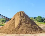 Ogromna hałda piasku, kluczowego składnika do produkcji betonu. Zastanawiasz się, ile piasku na m3 betonu? Tu jest go mnóstwo!