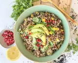 Bunter Quinoa Salat mit Avocado, Granatapfelkernen, Mais und frischer Petersilie. Ein gesundes und leckeres Gericht.