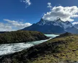 Wodospad w **Torres del Paine** z turkusową wodą i ośnieżonymi szczytami w tle.