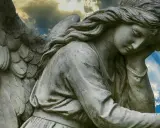 Kamienna rzeźba anioła zamyślonego pod niebem. 1333 znaczenie tego widoku może być symbolem nadziei.