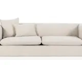 En ljusbeige bäddsoffa med två kuddar. Perfekt för gäster eller en mysig kväll.