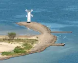 Latarnia morska w kształcie wiatraka, idealne miejsce na wakacje w Polsce. Widok na morze, plażę i ławicę z łabędziami.