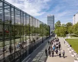 Studenci idący do budynku z lustrzaną fasadą, idealne miejsce na marketing studia wrocław.