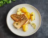 Gebratener Seehecht mit Haut, serviert mit Salzkartoffeln und Zitrone. Ein köstliches Gericht, das zeigt, wie man Seehecht mit Haut zubereitet.