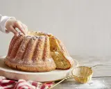 Un enfant touche un Kougelhopf, une des spécialités alsace, saupoudré de sucre glace. Une tranche est coupée, révélant des raisins secs.