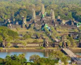 Majestatyczna świątynia Angkor Wat w Siem Reap, otoczona bujną zielenią, z mostem i jeziorem w tle.