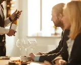 Ein Sommelier präsentiert eine Weinflasche. Die Bedeutung eines Sommeliers liegt in der Weinberatung und -auswahl.