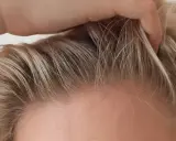 Dłoń delikatnie przeczesuje jasne włosy, ukazując drobne kosmyki, które zdradzają, jak ujarzmić baby hair.