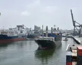 Navi da carico e gru nel porto di Casablanca. Un rimorchiatore assiste una nave portacontainer.