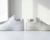 Dwa białe buty Nike Air Force 1, jeden świeży, drugi lekko zużyty. Nike to amerykańska marka.
