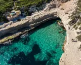 Malta oferuje malownicze plaze, jak ta z turkusową wodą i skalistymi klifami, gdzie można podziwiać piękno natury.