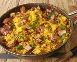Arroz paisa en sartén, con trozos de tocino crujiente, maíz y cilantro fresco. ¡Un festín para los sentidos!