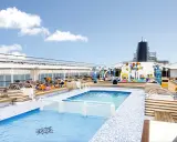 Ponte 8 cabine MSC Armonia: piscina e area giochi acquatica sul ponte superiore, con lettini e persone che si rilassano.