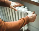 Manas ajustando el termostato para limpiar radiadores y optimizar la calefacción.