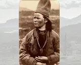 Porträtt av en person med samiskt utseende, klädd i traditionella kläder och en hög mössa. Bakgrunden visar ett bergigt landskap.