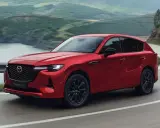 Czerwona Mazda CX-60 3.3 Diesel pokonuje zakręt na malowniczej drodze.
