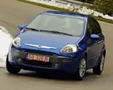 Niebieski Fiat z polskimi tymczasowymi tablicami rejestracyjnymi SO 320 B jedzie po krętej drodze, po bokach śnieg.